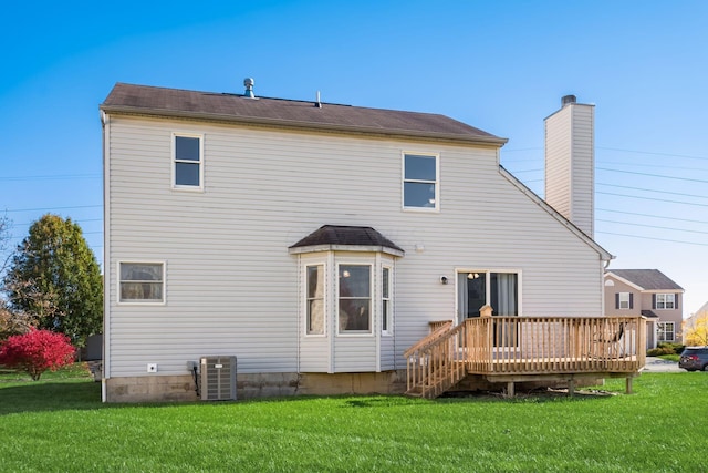 rear view of house featuring central air condition unit, a wooden deck, and a yard