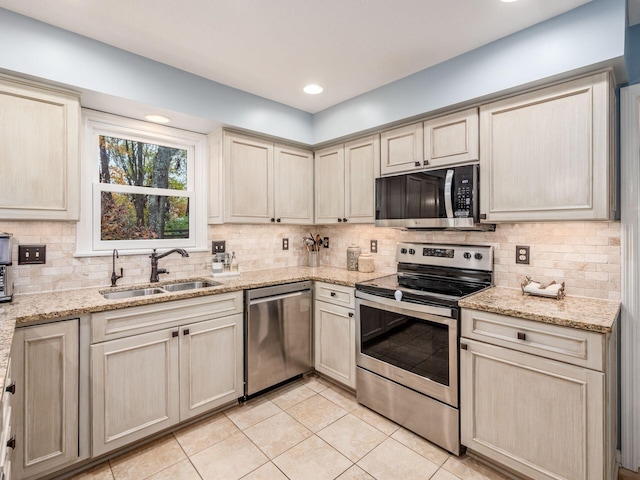 kitchen featuring tasteful backsplash, sink, light tile patterned floors, and appliances with stainless steel finishes