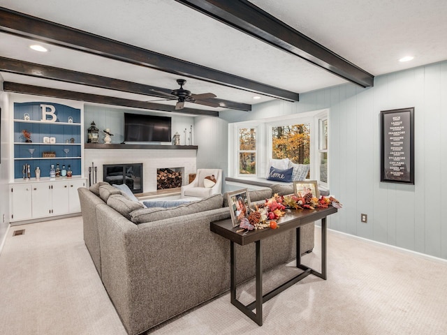 carpeted living room with ceiling fan, beamed ceiling, and a textured ceiling