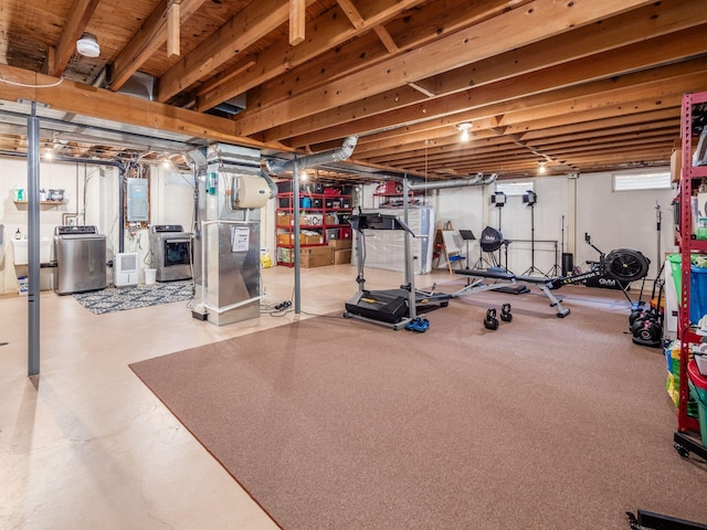 workout area featuring electric panel, separate washer and dryer, and heating unit