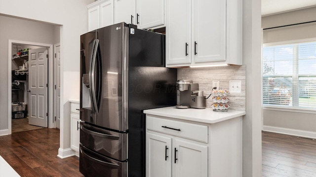 kitchen featuring backsplash, white cabinetry, dark hardwood / wood-style flooring, and stainless steel refrigerator with ice dispenser