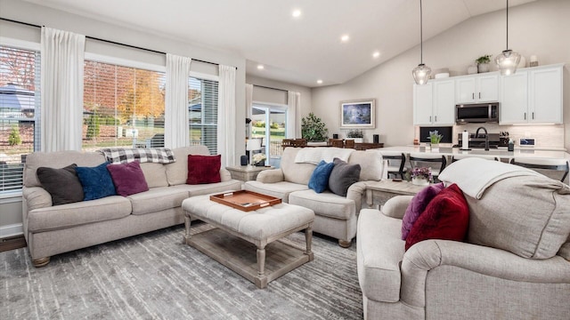 living room featuring lofted ceiling and sink