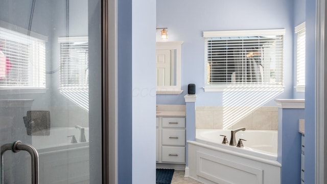 bathroom with plus walk in shower, vanity, and tile patterned flooring