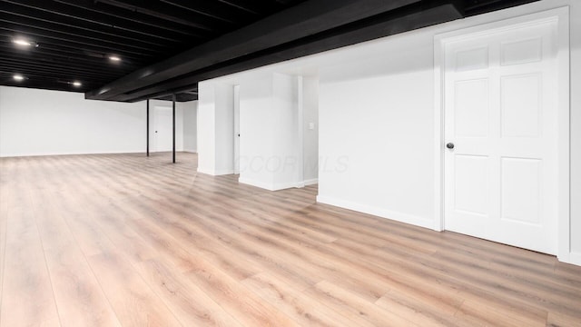 basement with light hardwood / wood-style flooring