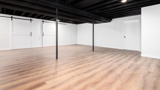 basement with light hardwood / wood-style flooring