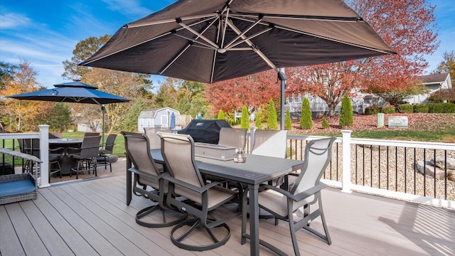 wooden terrace with area for grilling and a shed