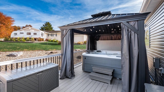 deck with a gazebo, a hot tub, and a lawn