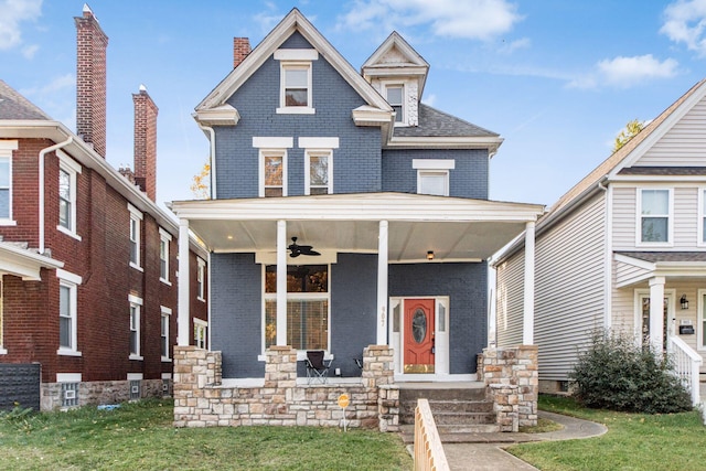 view of front of property with covered porch, ceiling fan, and a front yard