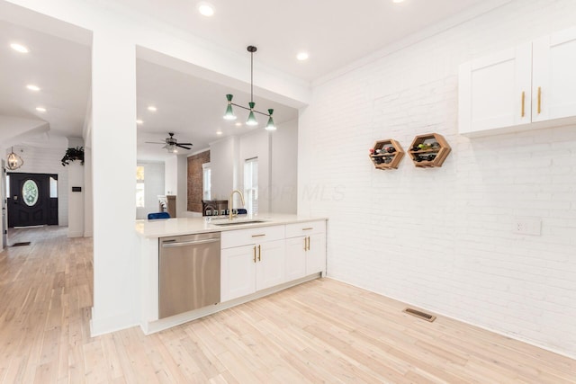 kitchen featuring dishwasher, white cabinets, sink, light wood-type flooring, and decorative light fixtures