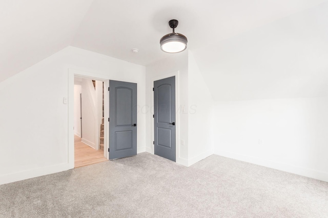 additional living space with light carpet and lofted ceiling