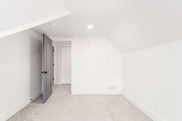 bonus room with light colored carpet and lofted ceiling