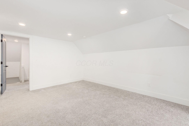 unfurnished room with light carpet and vaulted ceiling