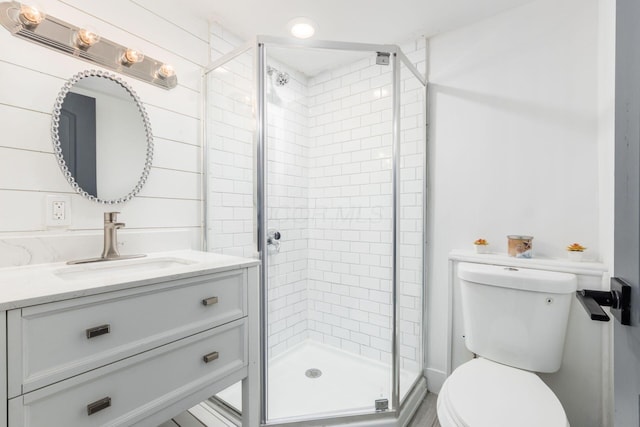 bathroom with walk in shower, vanity, and toilet