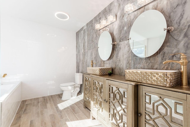 bathroom featuring hardwood / wood-style flooring, vanity, toilet, and tile walls