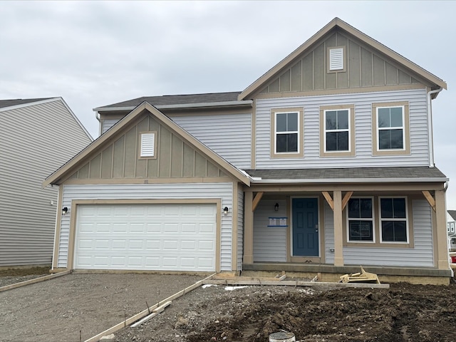 view of front of property featuring board and batten siding, aphalt driveway, a garage, and roof with shingles