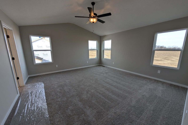 carpeted empty room featuring lofted ceiling, ceiling fan, and baseboards