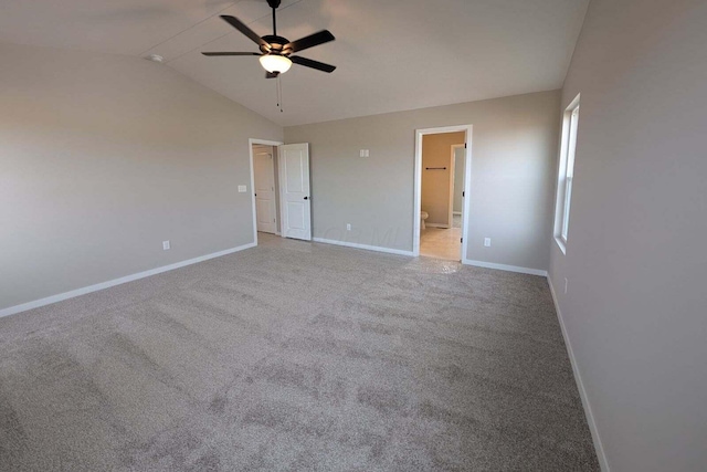 unfurnished bedroom featuring lofted ceiling, carpet flooring, ceiling fan, ensuite bath, and baseboards