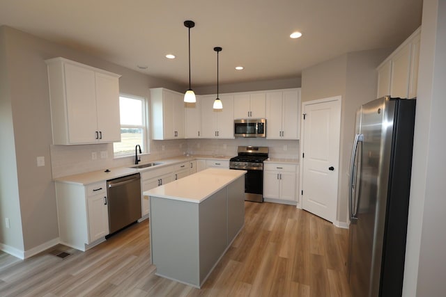 kitchen featuring light wood-style flooring, appliances with stainless steel finishes, backsplash, and a sink