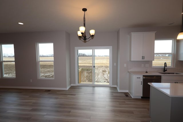 kitchen featuring a sink, white cabinetry, light countertops, backsplash, and dishwasher