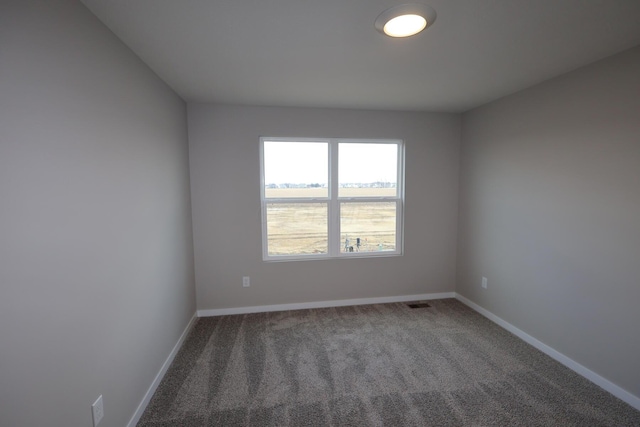 carpeted empty room featuring baseboards