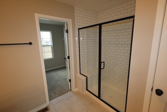 full bath featuring a shower stall, baseboards, and tile patterned floors