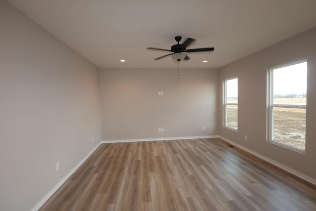 unfurnished room with light wood finished floors, recessed lighting, a ceiling fan, and baseboards