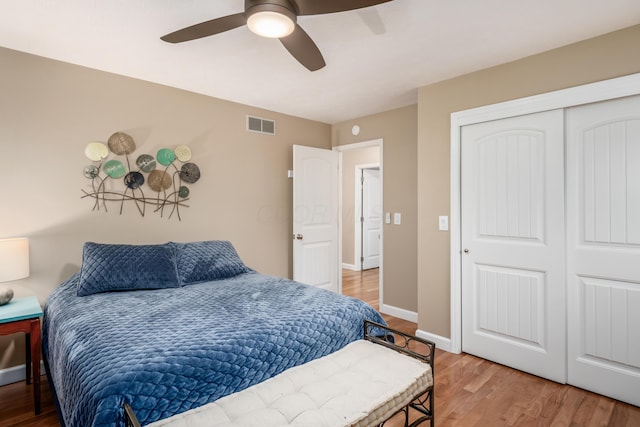 bedroom with ceiling fan, wood-type flooring, and a closet