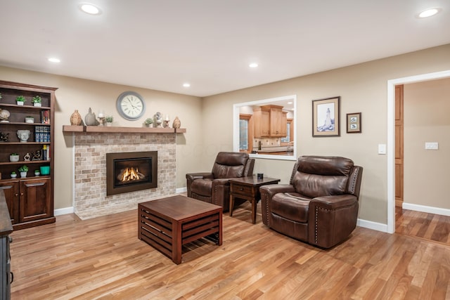 living room with light hardwood / wood-style floors and a brick fireplace