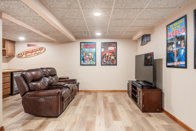 living room featuring a drop ceiling and light hardwood / wood-style floors