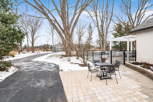 snow covered patio featuring a pergola