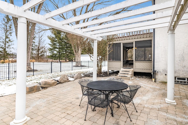 snow covered patio featuring a pergola and a sunroom