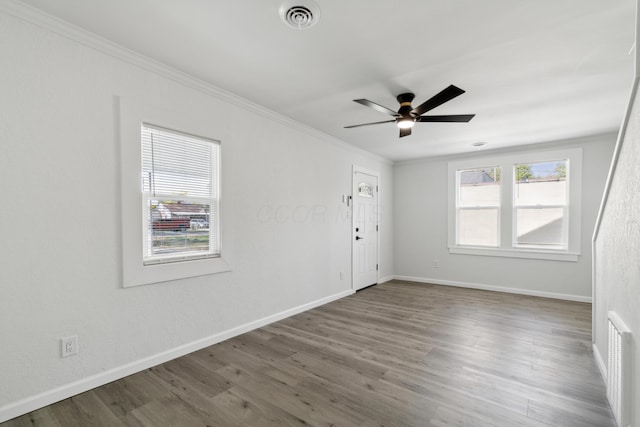 empty room with hardwood / wood-style flooring, ceiling fan, and ornamental molding