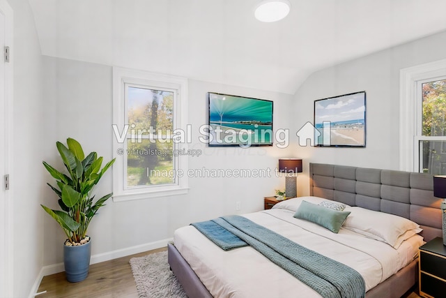 bedroom featuring wood-type flooring and vaulted ceiling