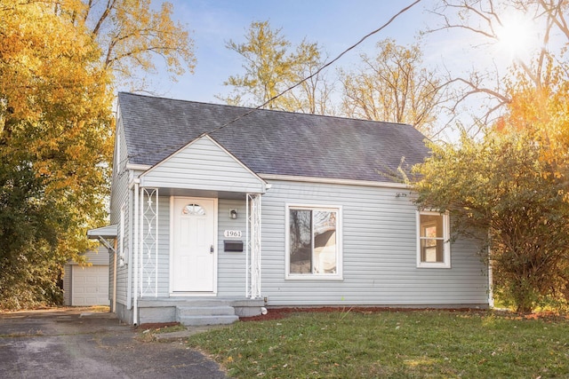 1961 Dartmouth Ave, Columbus, OH 43219 - view of front of home with roof with shingles, an outdoor structure, a front yard, and driveway