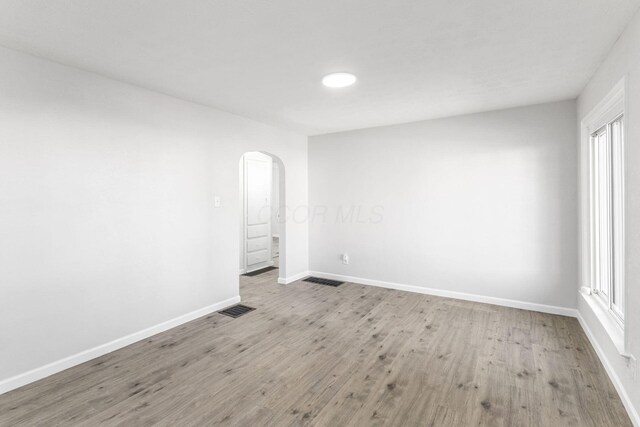 1961 Dartmouth Ave, Columbus, OH 43219 - spare room with arched walkways, wood finished floors, and healthy amount of natural light