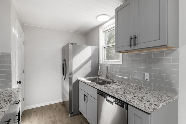 1961 Dartmouth Ave, Columbus, OH 43219 - kitchen featuring appliances with stainless steel finishes, gray cabinetry, wood finished floors, backsplash, and light stone countertops