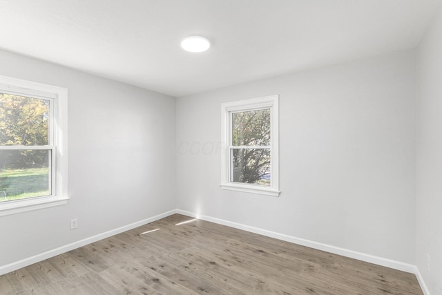 spare room featuring hardwood / wood-style flooring and plenty of natural light