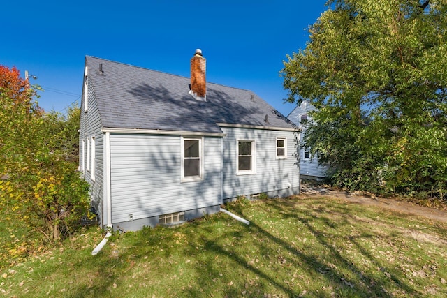 1961 Dartmouth Ave, Columbus, OH 43219 - back of house with a chimney, a yard, and roof with shingles