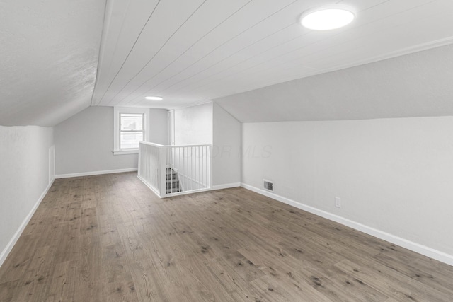 bonus room featuring wood-type flooring and vaulted ceiling