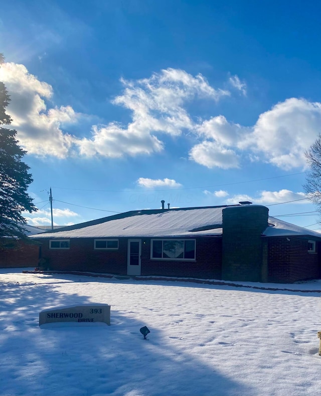 view of snow covered rear of property