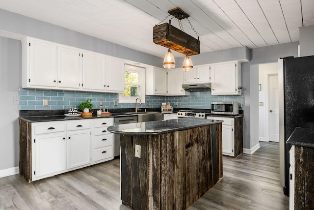 kitchen with sink, a center island, stainless steel appliances, white cabinets, and light wood-type flooring