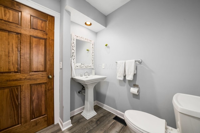 bathroom featuring hardwood / wood-style floors and toilet