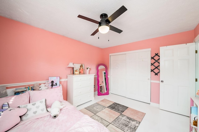 bedroom with a textured ceiling, a closet, and ceiling fan