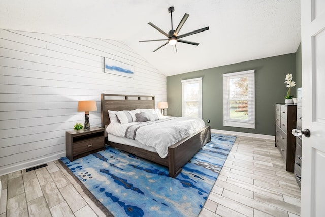 bedroom featuring a textured ceiling, ceiling fan, light hardwood / wood-style floors, and lofted ceiling