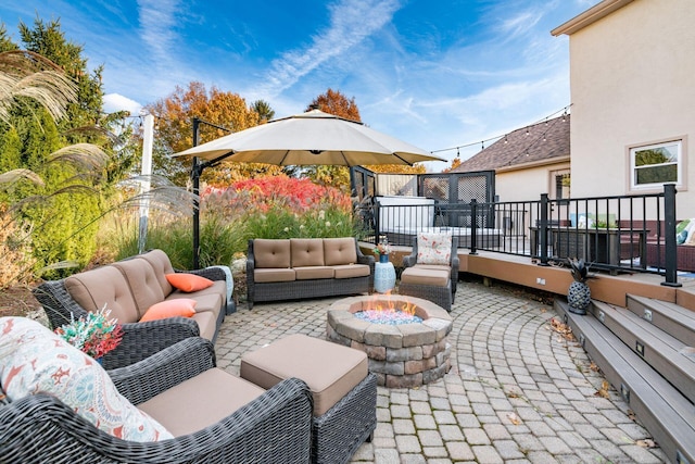 view of patio with an outdoor living space with a fire pit