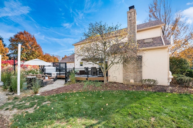 back of house with a yard, an outdoor living space, and a wooden deck