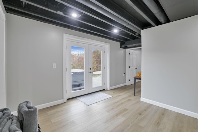 doorway with beamed ceiling, french doors, and light hardwood / wood-style flooring