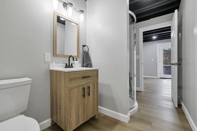 bathroom featuring vanity, hardwood / wood-style flooring, and toilet