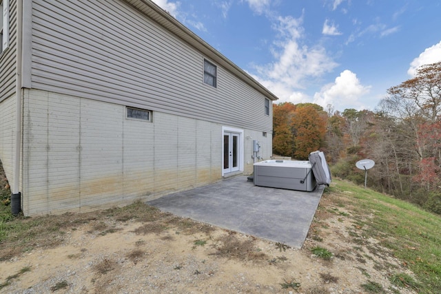 view of side of home featuring a patio area and a hot tub