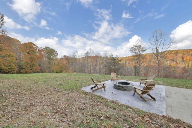 view of yard featuring a mountain view and an outdoor fire pit